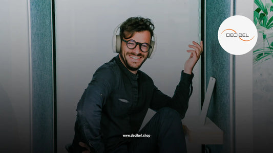 A man with white headphones and blue shirt smiling looking at the camera