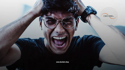 a man with glasses yelling and holding his head with hands