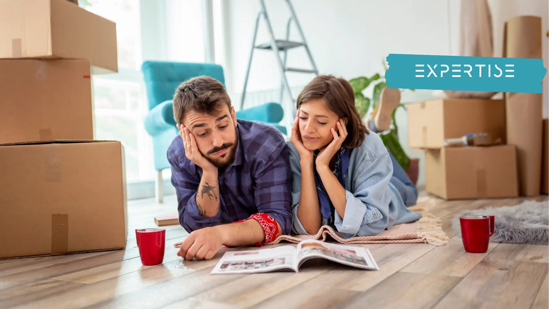 a couple looking at a magazine on the floor of their renovated home struggling to make a decision