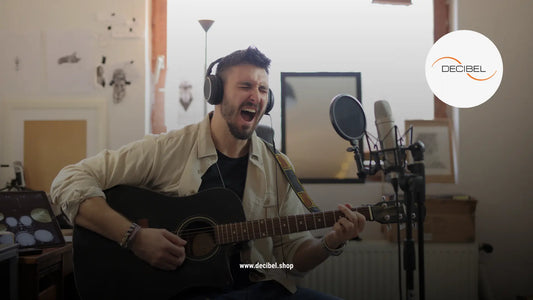 man singing and playing guitar in a home music studio